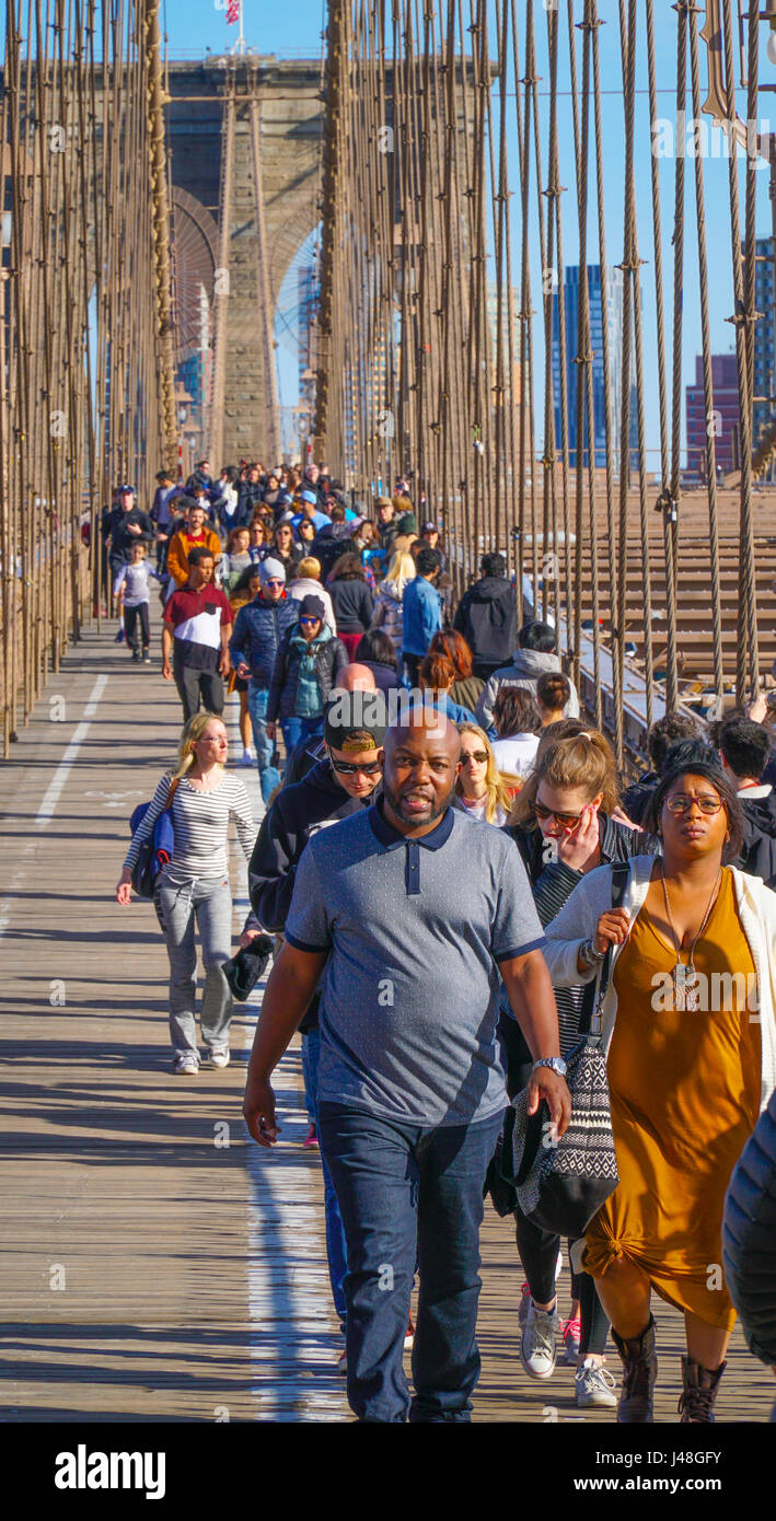 People walking over beautiful Brooklyn Bridge in New York MANHATTAN