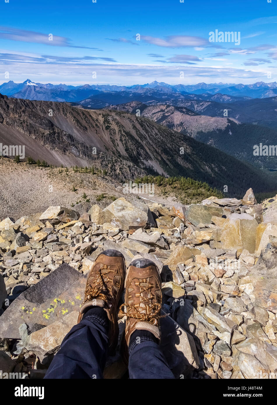 A woman's feet standing on a rock at the top of Mount Frosty, overlooking Windy Joe in E.C. Manning Provincial Park; British Columbia, Canada Stock Photo