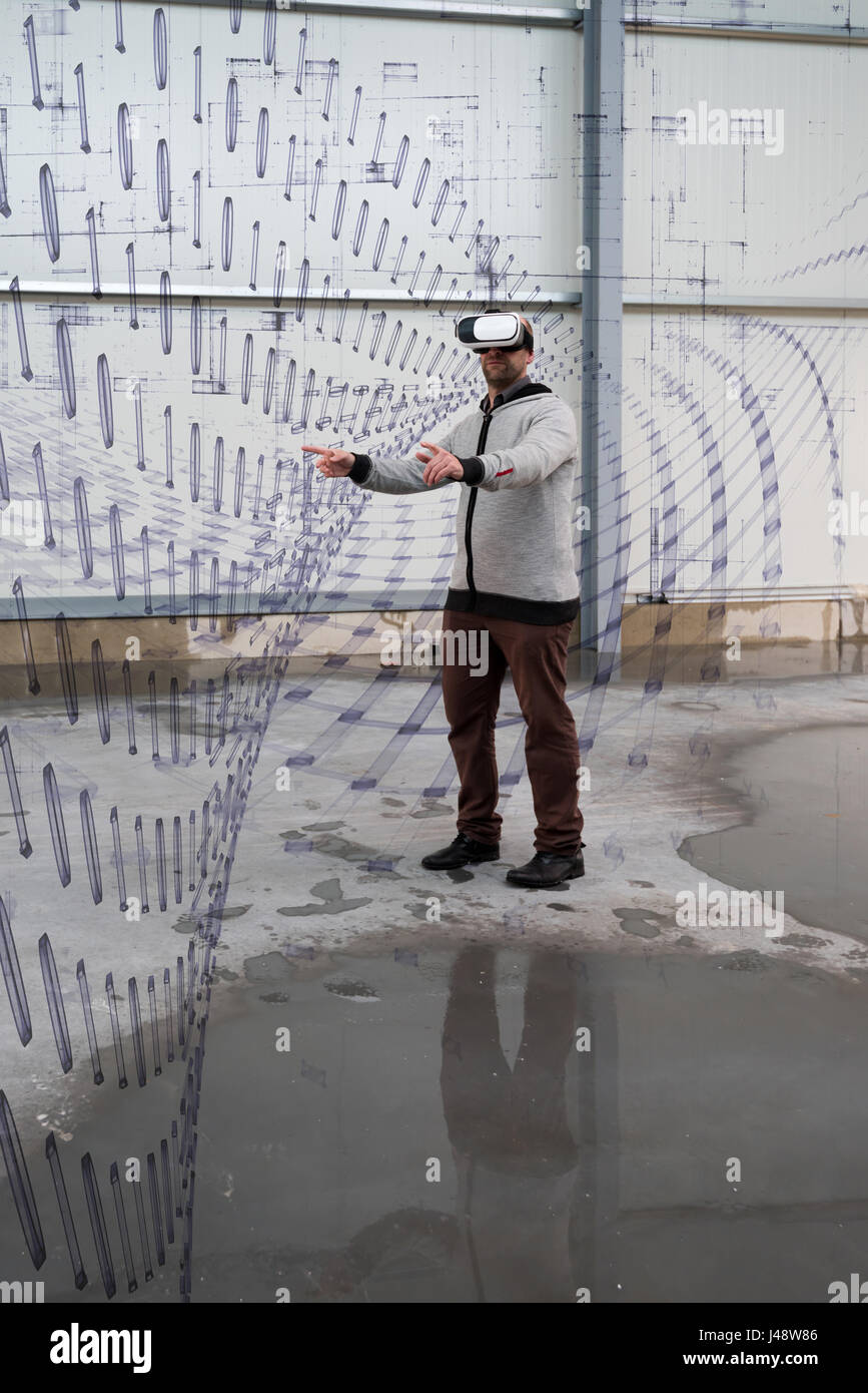 Architect with VR visor exploring industrial building environment Stock Photo