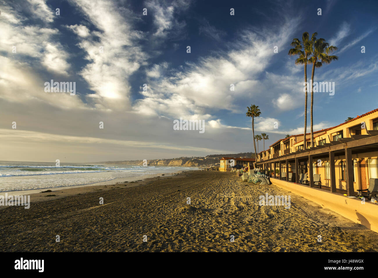 La Jolla Shores Beach Waterfront Hotel, Palm Trees and Pacific Ocean California Coast. Dramatic Sky Clouds Distant Torrey Pines State Reserve Horizon Stock Photo