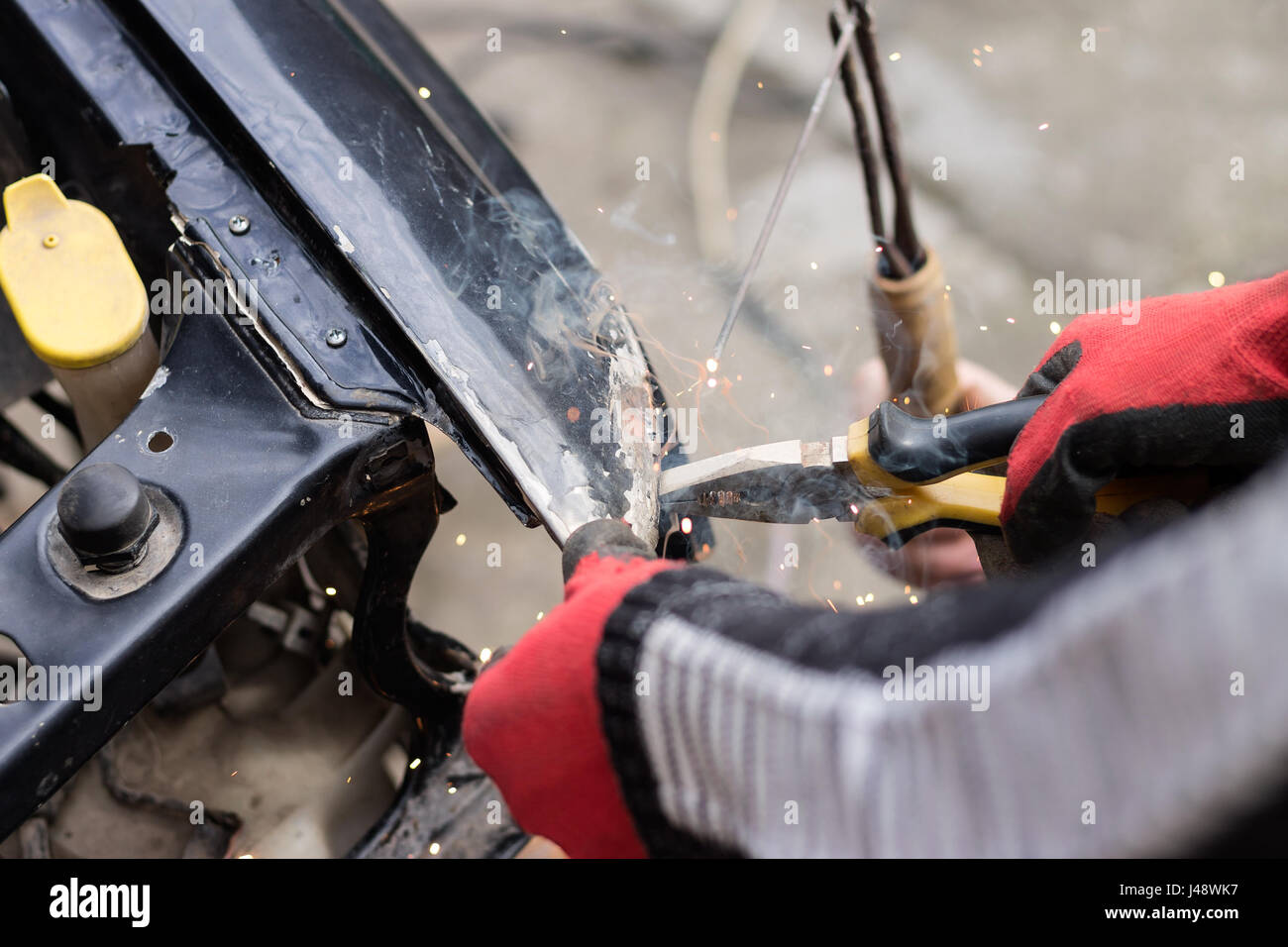 Repair service worker fix damaged car after crash on the road. Working