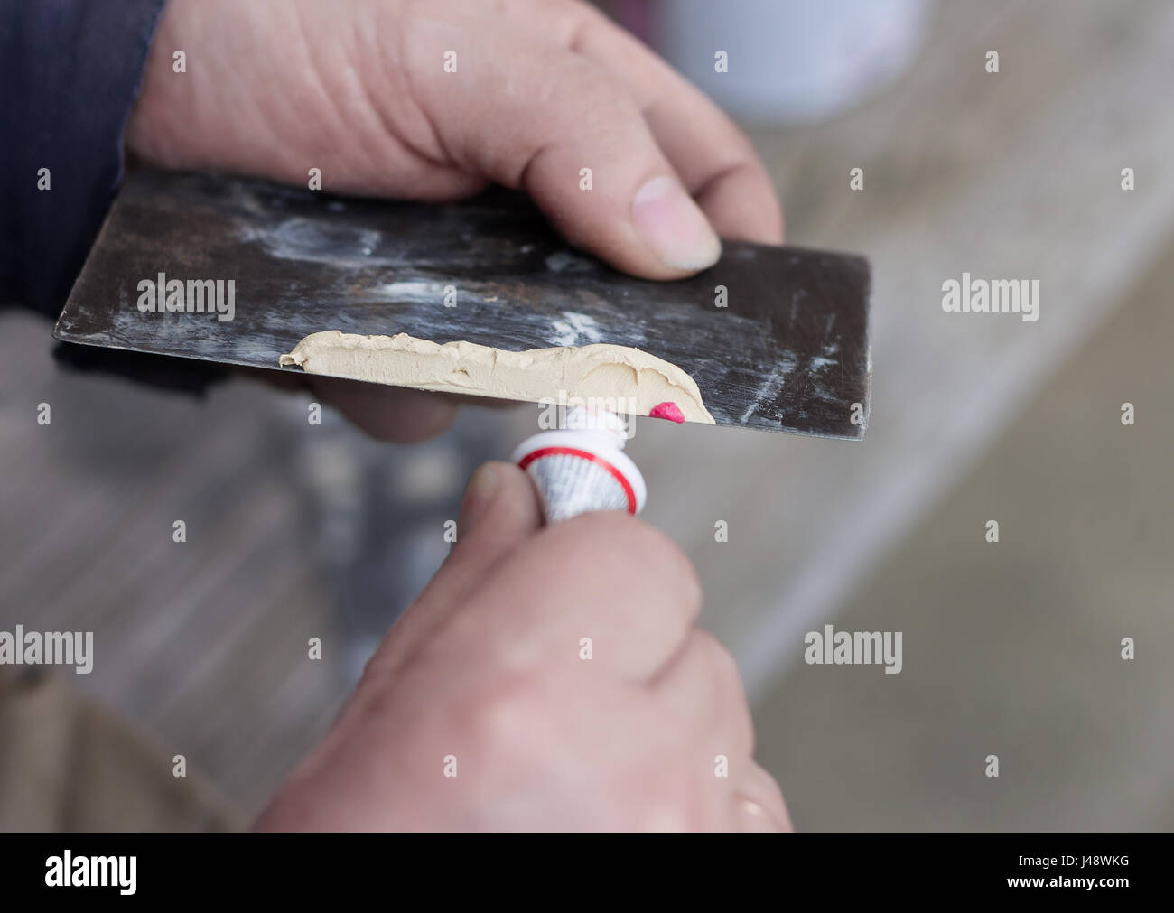 Worker mix red hardener with filler material putty. Car repairing