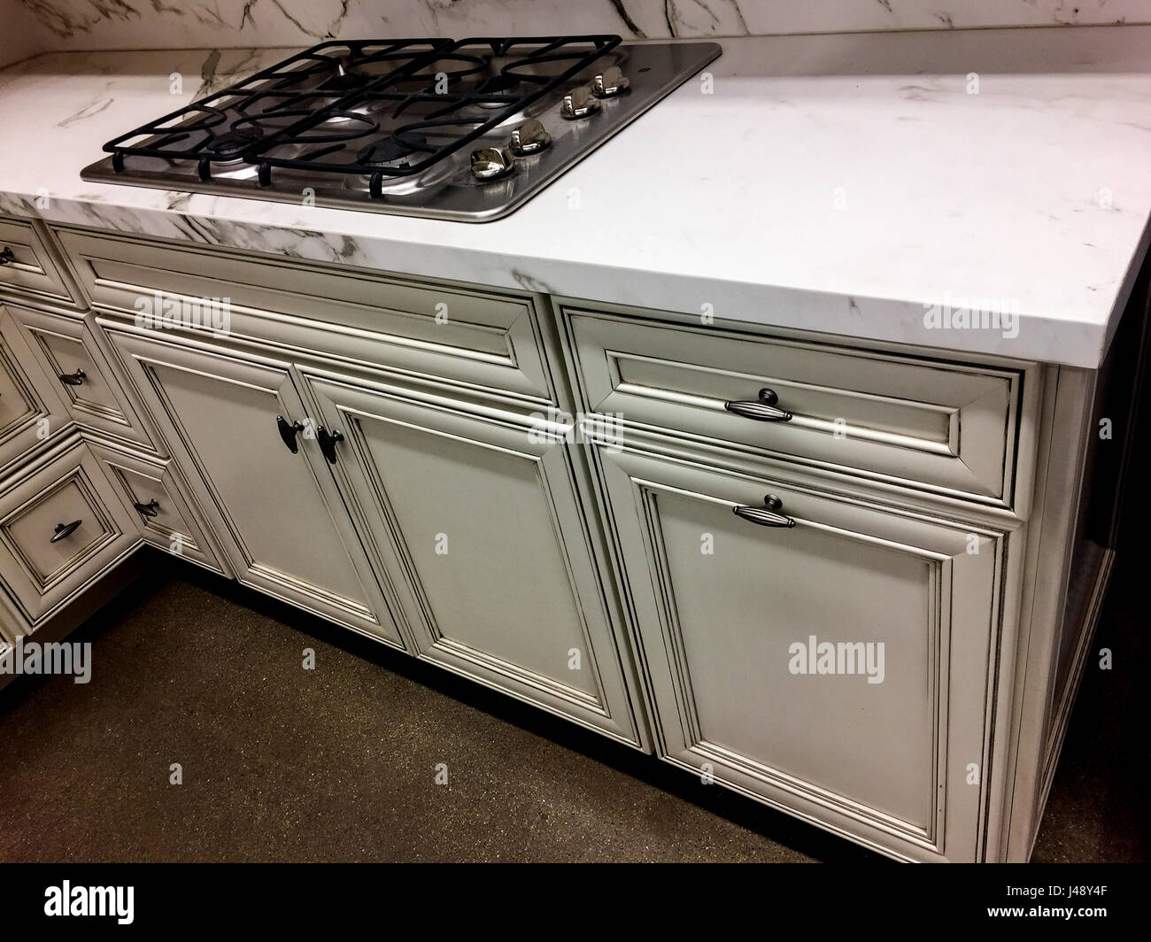 Kitchen cabinets with marble countertop and cooktop Stock Photo