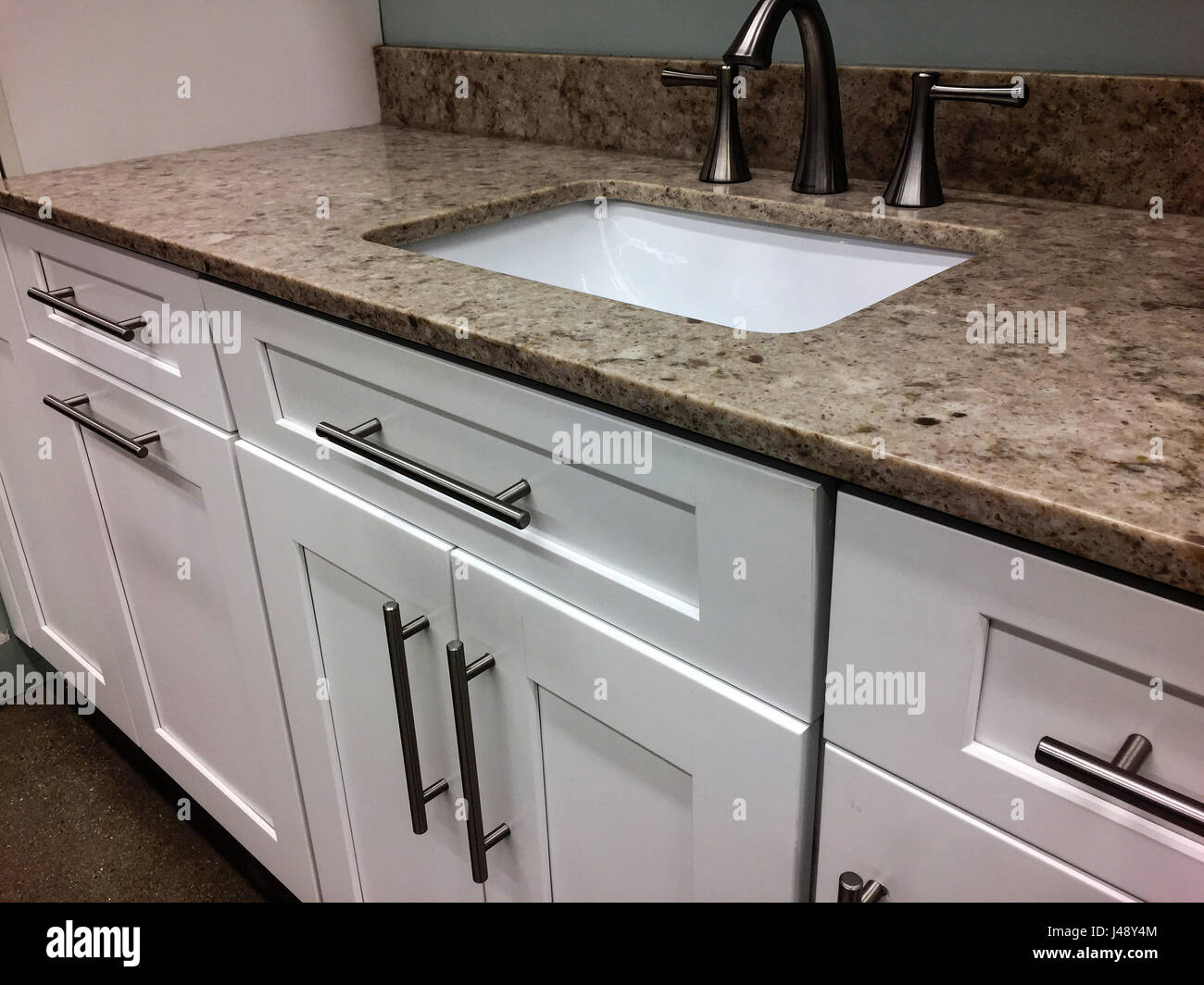 Kitchen white cabinets with granite countertop with sink and faucet Stock Photo