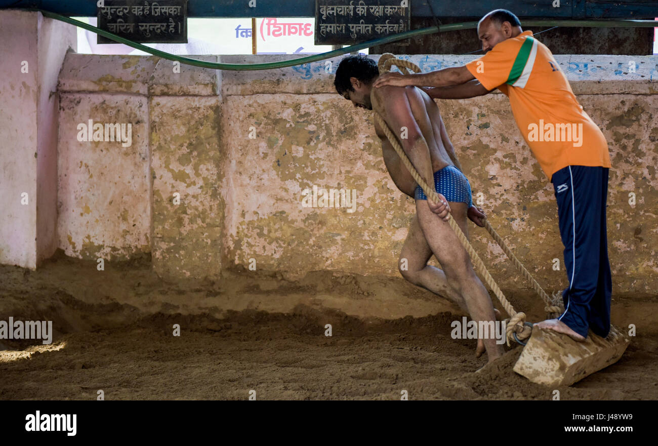 New Delhi, India. 2nd May, 2017. A Pehlwani wrestler (L) levels the mud ground as part of the strength training in Guru Hanuman Akhara training center, in New Delhi, India, May 2, 2017. Pehlwani wrestling, also known as Kushti, is a traditional competitive sport which was developed in the Mughal era. Pehlwani is quite popular in the south Asian countries, especially in India. Credit: Bi Xiaoyang/Xinhua/Alamy Live News Stock Photo