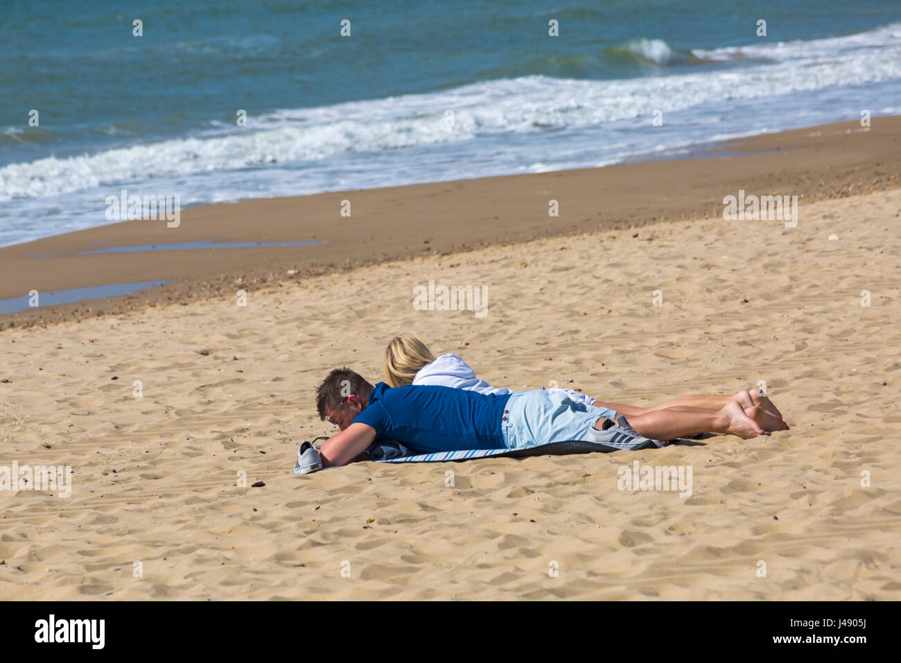 Bournemouth, Dorset, UK. 10th May, 2017. UK weather: lovely warm sunny day as visitors head to the seaside to make the most of the sunshine at Bournemouth beaches. Couple sunbathing on the beach. Credit: Carolyn Jenkins/Alamy Live News Stock Photo