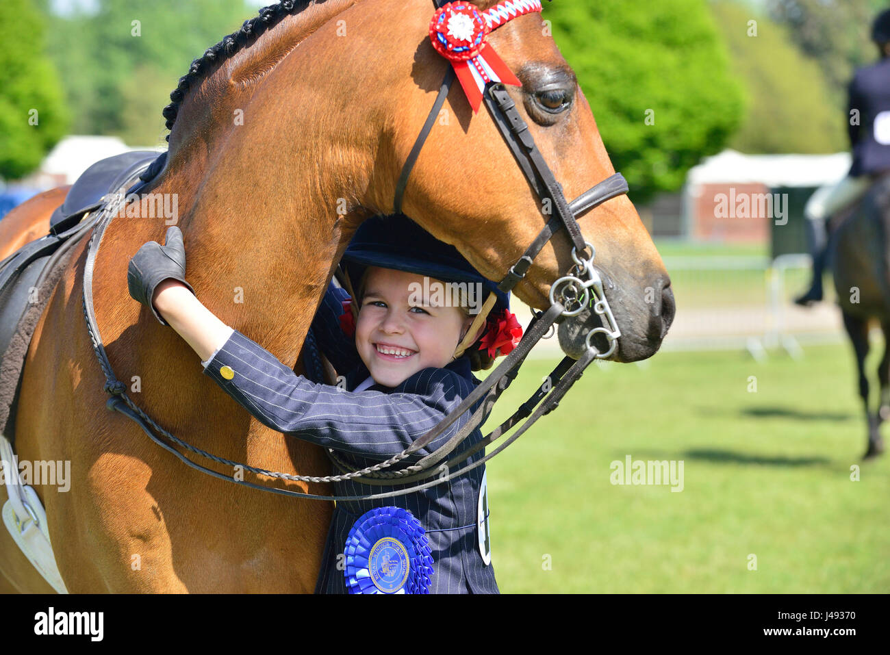 Gracie Aungier, 7 years old, hugs her pony Broadgrove Littlestar who together came Second in the Part Bred and Anglo Arabs, 148 cm and under, in the Adelaide Arena on a glorious sunny - Day 1 of the Royal Windsor Horse Show in the Windsor Castle Grounds Berkshire UK. Credit Gary Blake/Alamy Live Stock Photo
