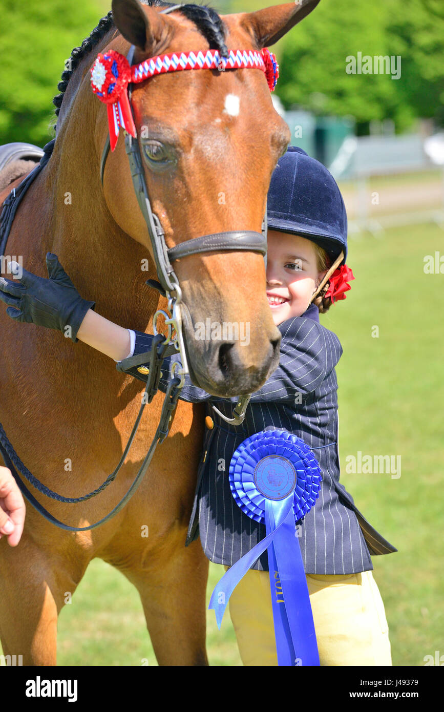 Gracie Aungier, 7 years old hugs her pony Broadgrove Littlestar who together came Second in the Part Bred and Anglo Arabs, 148 cm and under, in the Adelaide Arena on a glorious sunny - Day 1 of the Royal Windsor Horse Show in the Windsor Castle Grounds Berkshire UK. Credit Gary Blake/Alamy Live Stock Photo