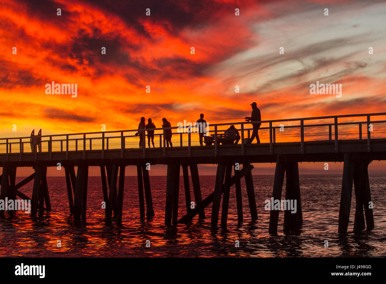 Adelaide, Australia. 11th May, 2017. A dramatic sunset develops over Adelaide beach from a jetty creating vibrant colours of pink and orange hues Credit: amer ghazzal/Alamy Live News  Stock Photo