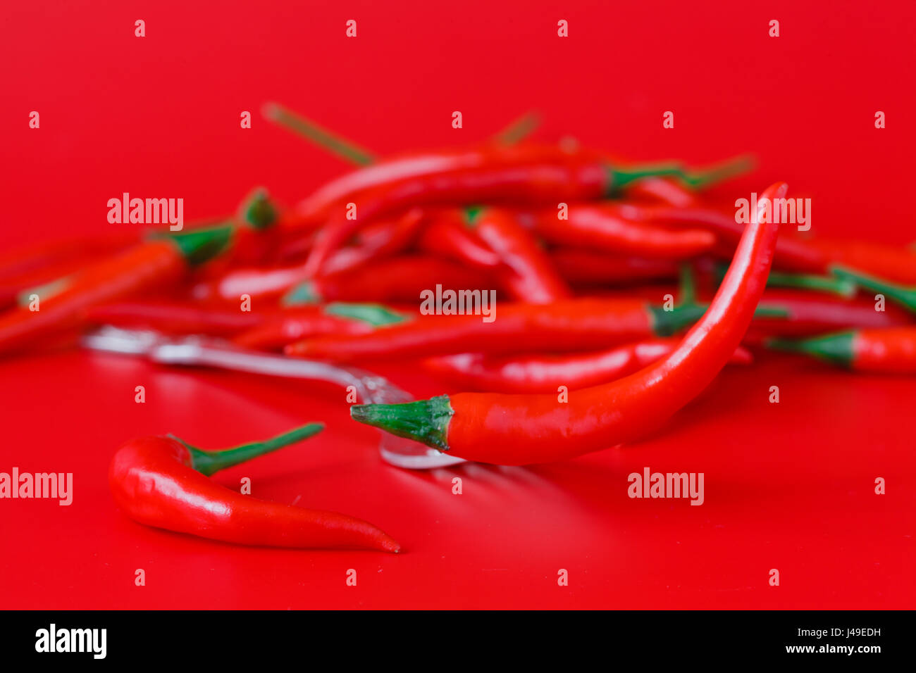 Pile of fresh red chili peppers on red background Stock Photo - Alamy