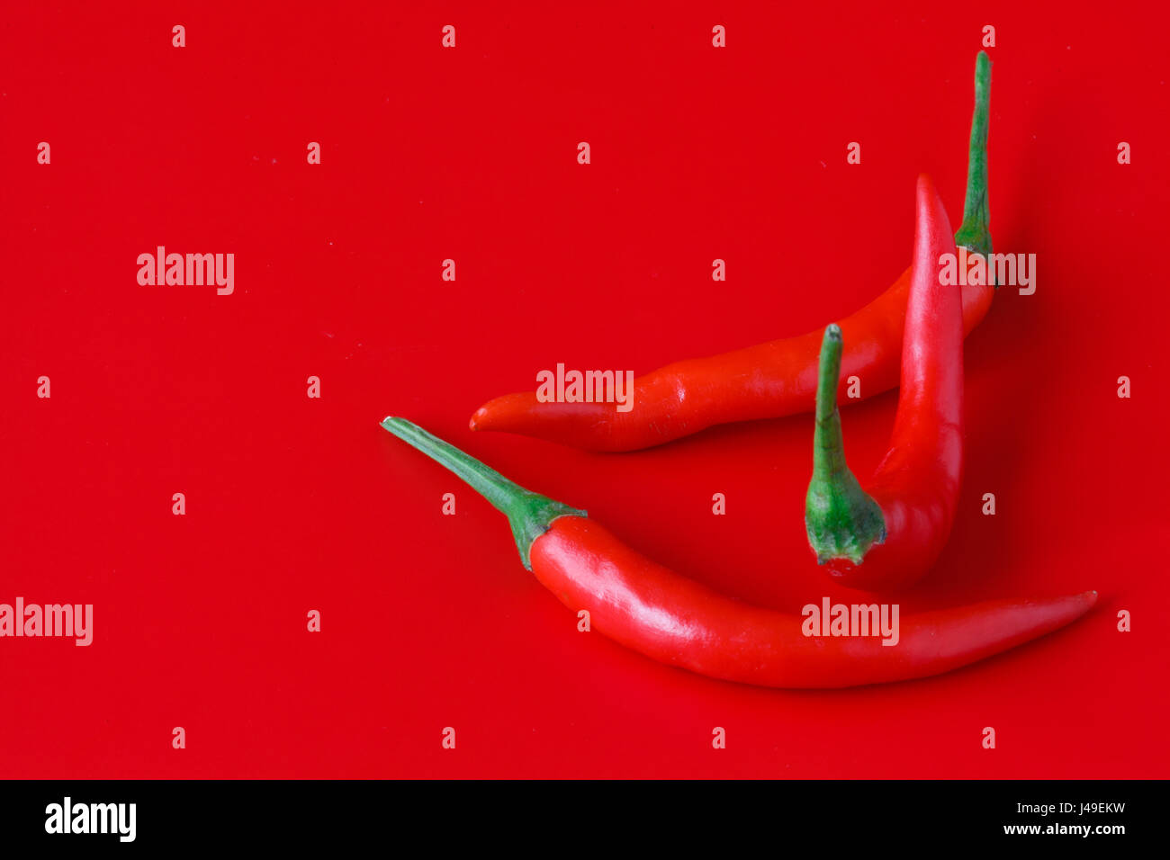 Pile of fresh red chili peppers on red background Stock Photo - Alamy