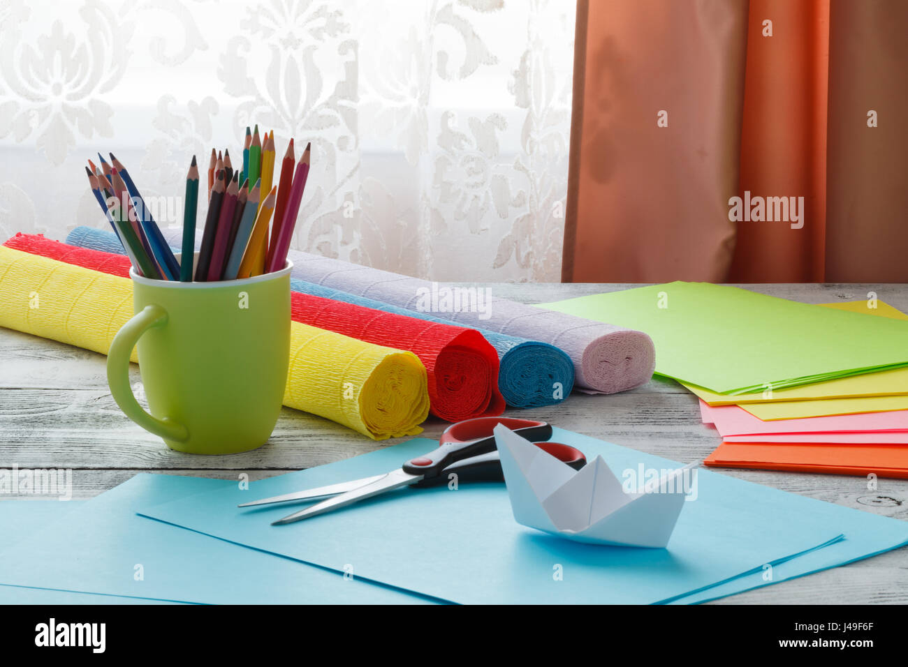 Set Of Origami Boats And Square Sheets Of Colored Paper On A