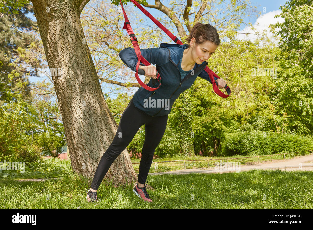 https://c8.alamy.com/comp/J49FGE/woman-sling-training-or-suspension-training-at-park-J49FGE.jpg