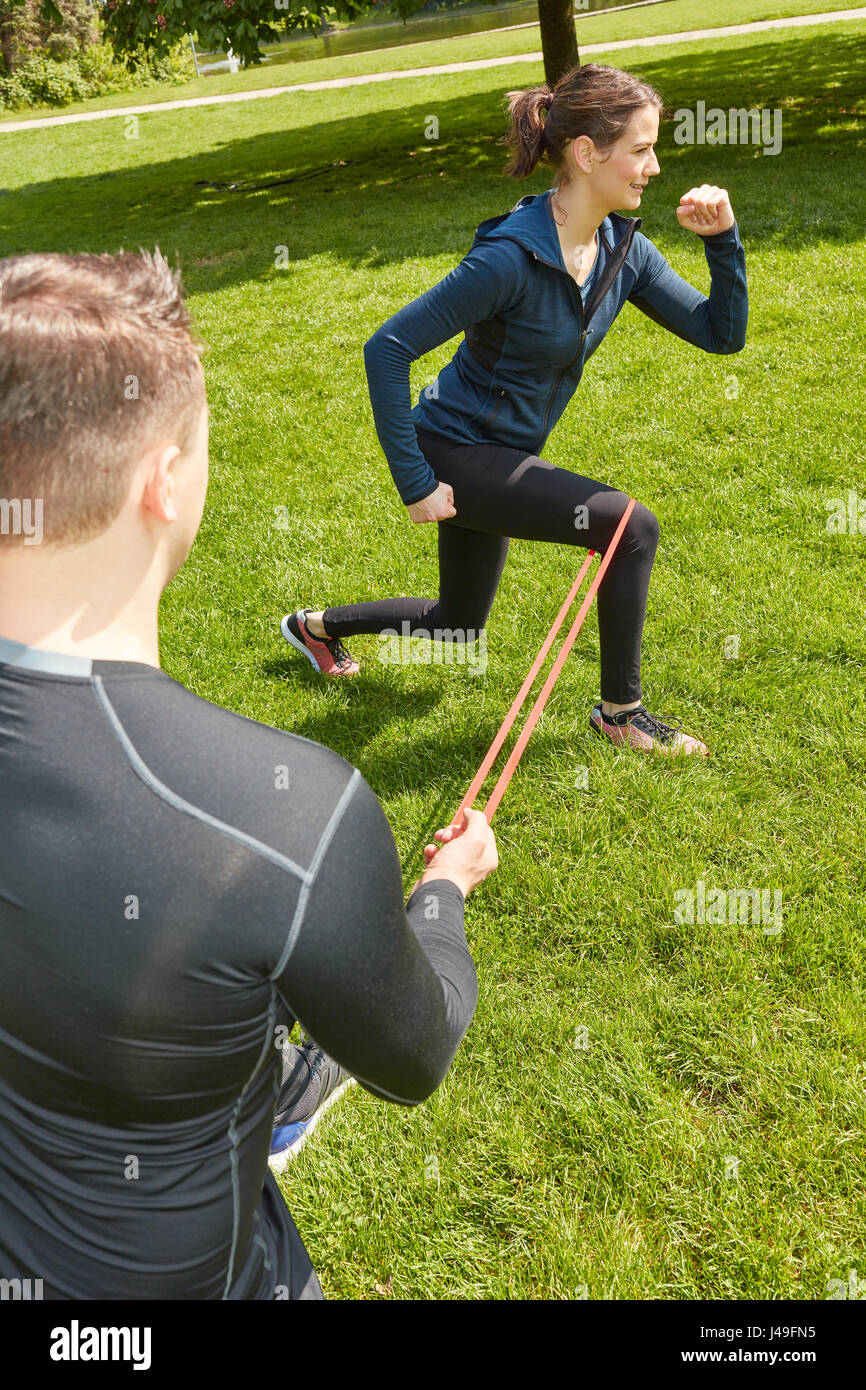 Woman doing leg workout with rubber band at the park Stock Photo
