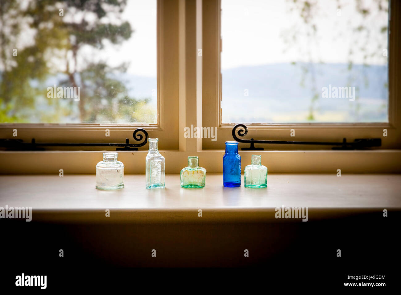 Refined country living - Five stylish little glass bottles sitting on a window sill Stock Photo