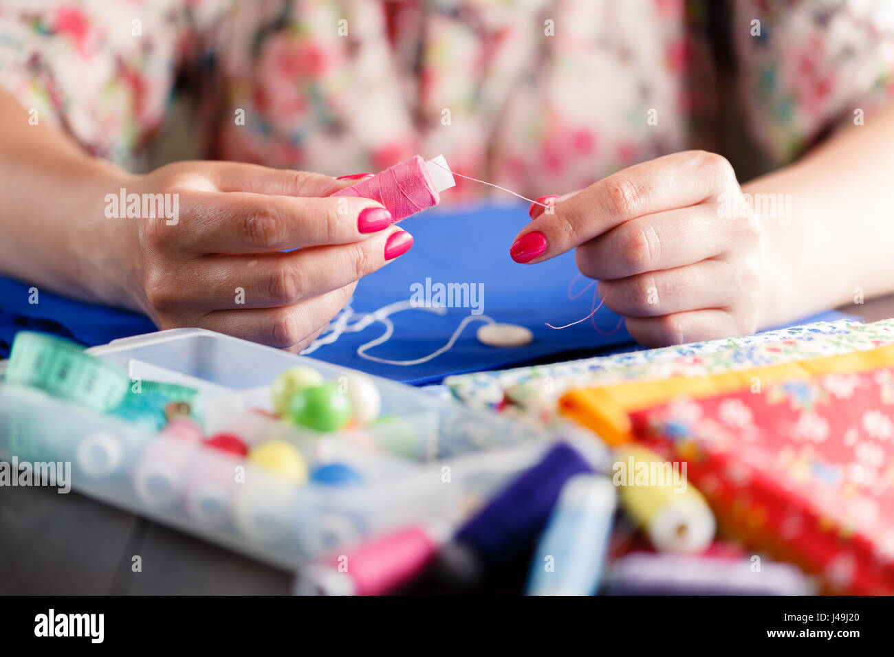 Closeup of woman hands sewing a button Stock Photo - Alamy