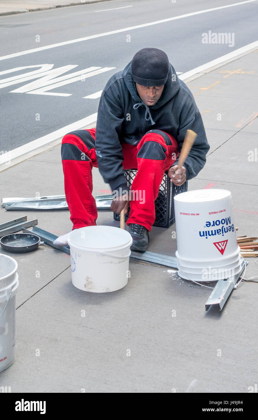 African busker drummer playing complex rhythms on plastic buckets and