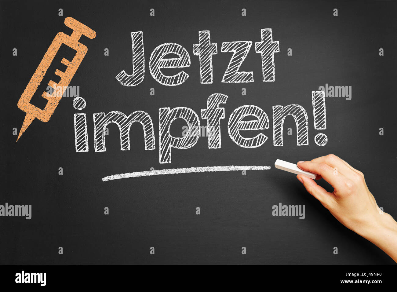 German slogan 'Jetzt impfen' (vaccinate now) written with chalk on blackboard Stock Photo