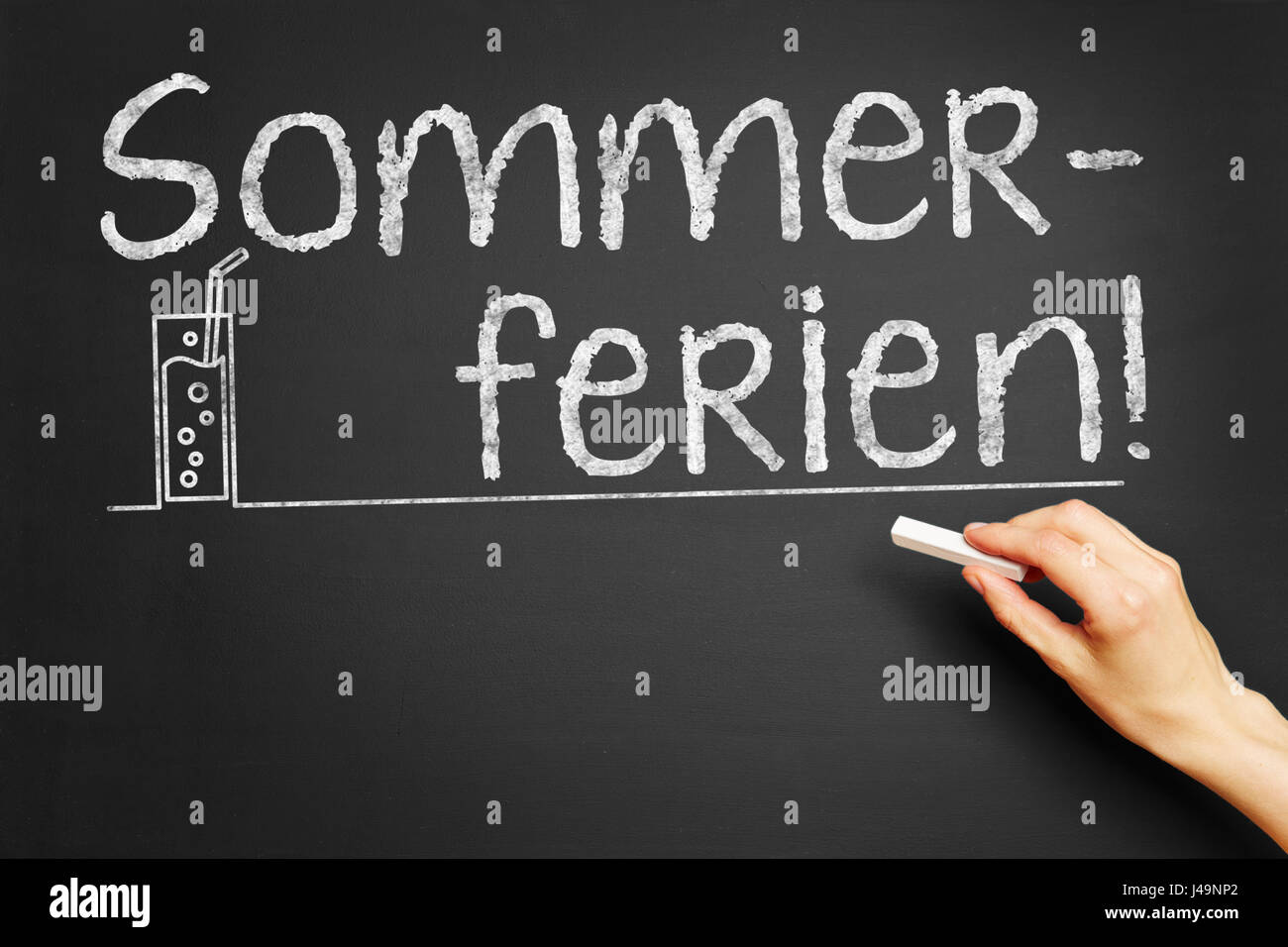 Hand writes in German 'Sommerferien!' (summer vacation) on blackboard Stock Photo