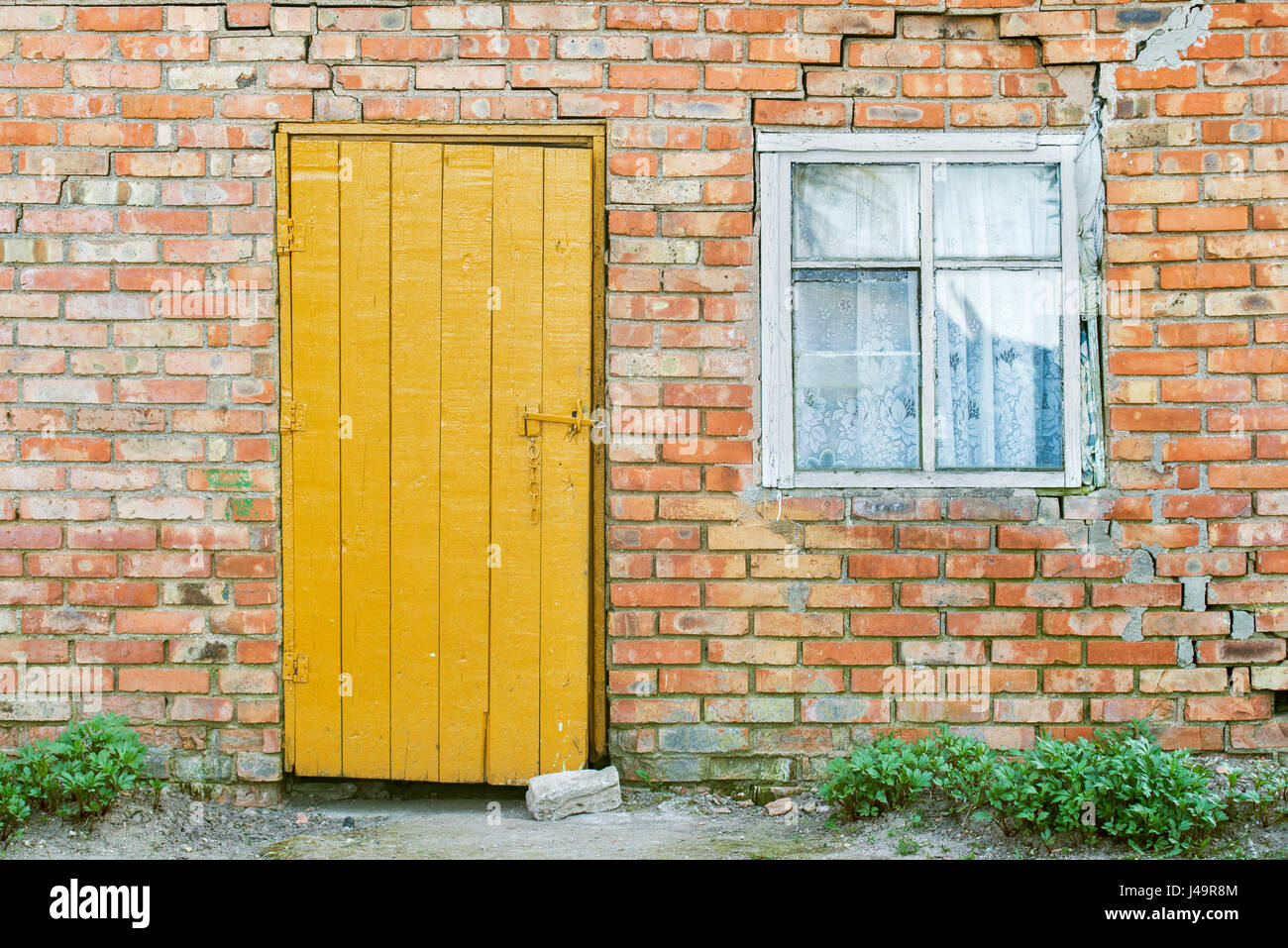 red brick wall, wooden door and window Stock Photo - Alamy