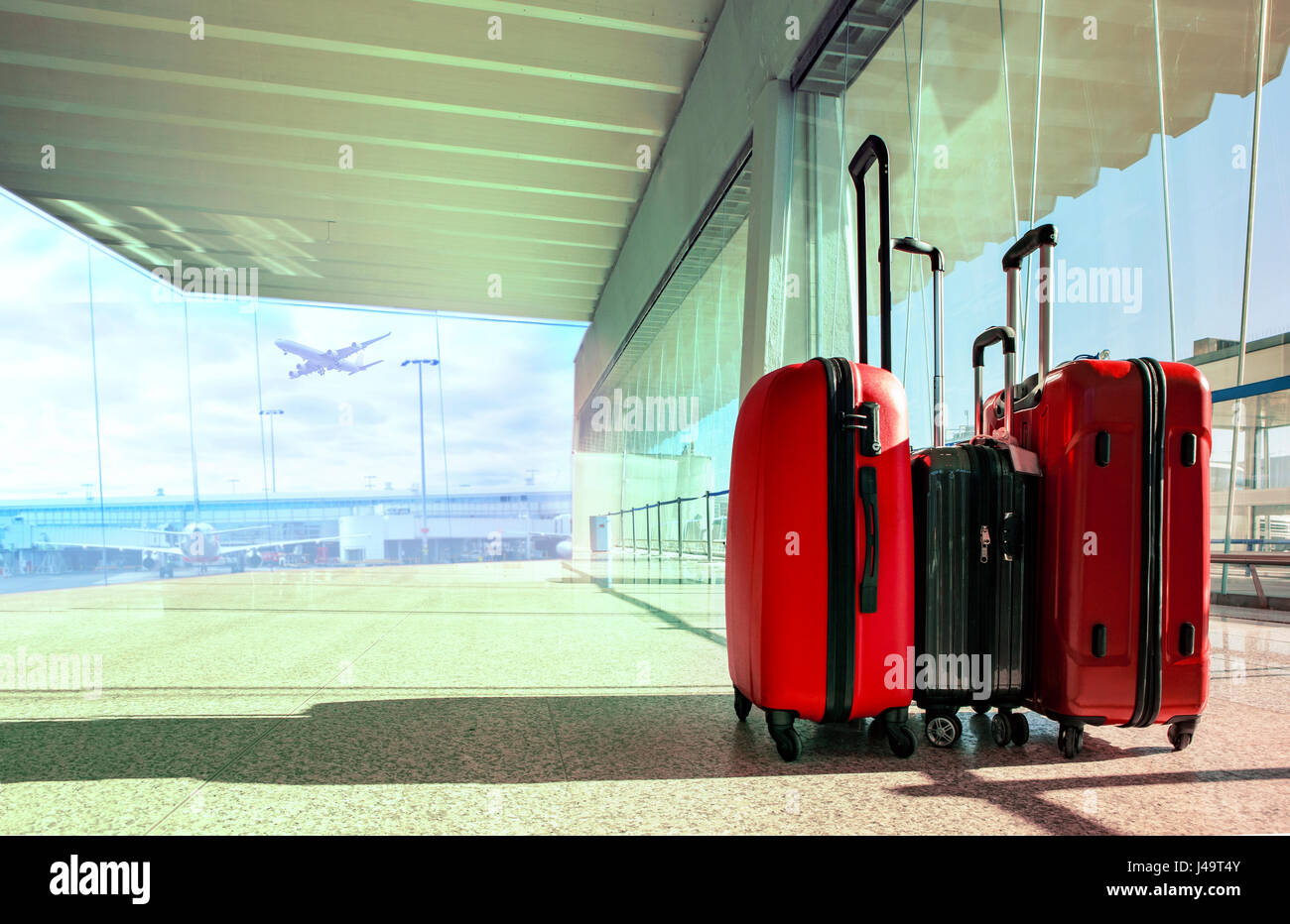 stack of traveling luggage in airport terminal and passenger plane ...