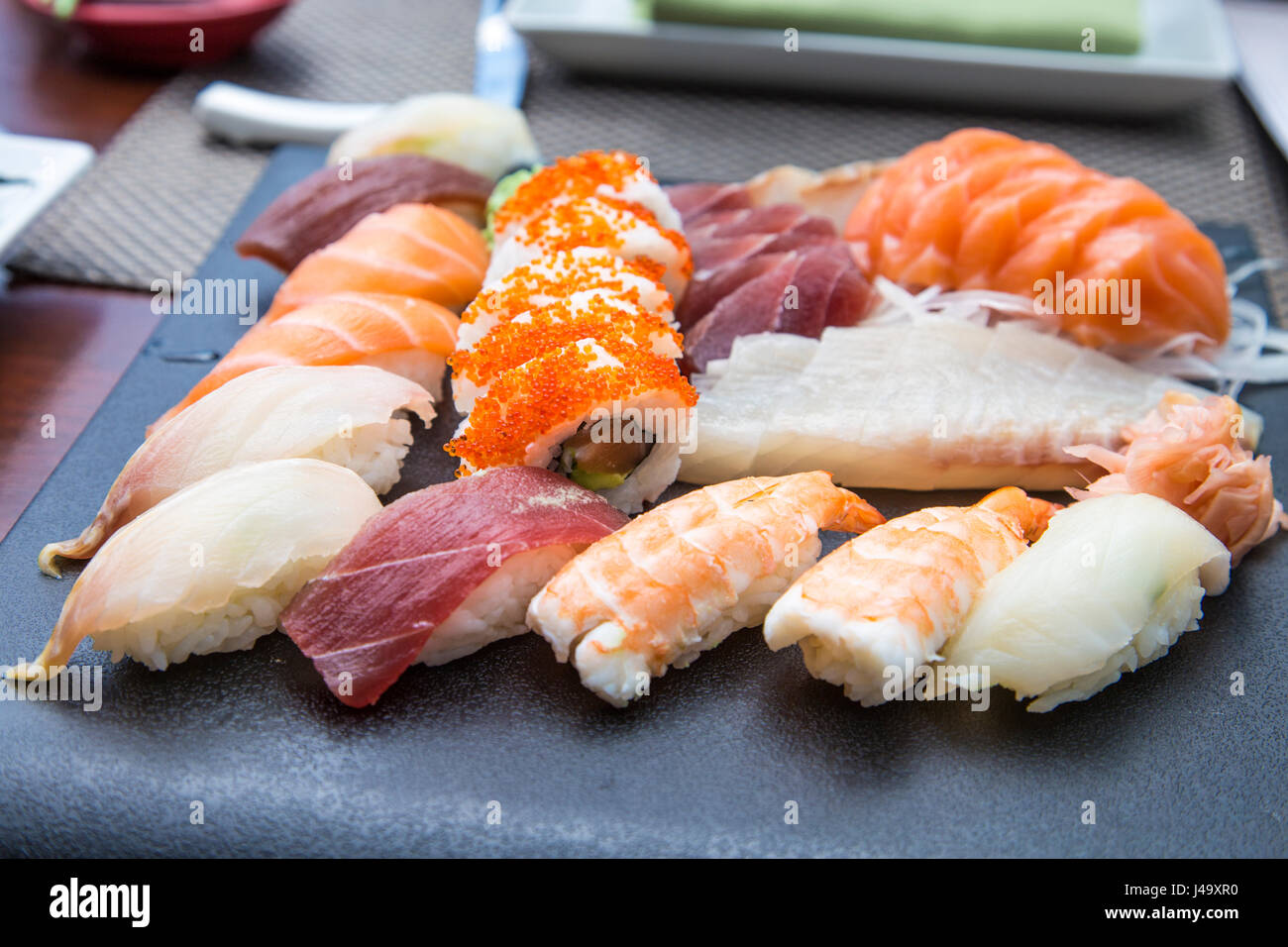 A selection of Japanese sushi and sashimi with daikon garnish Stock Photo