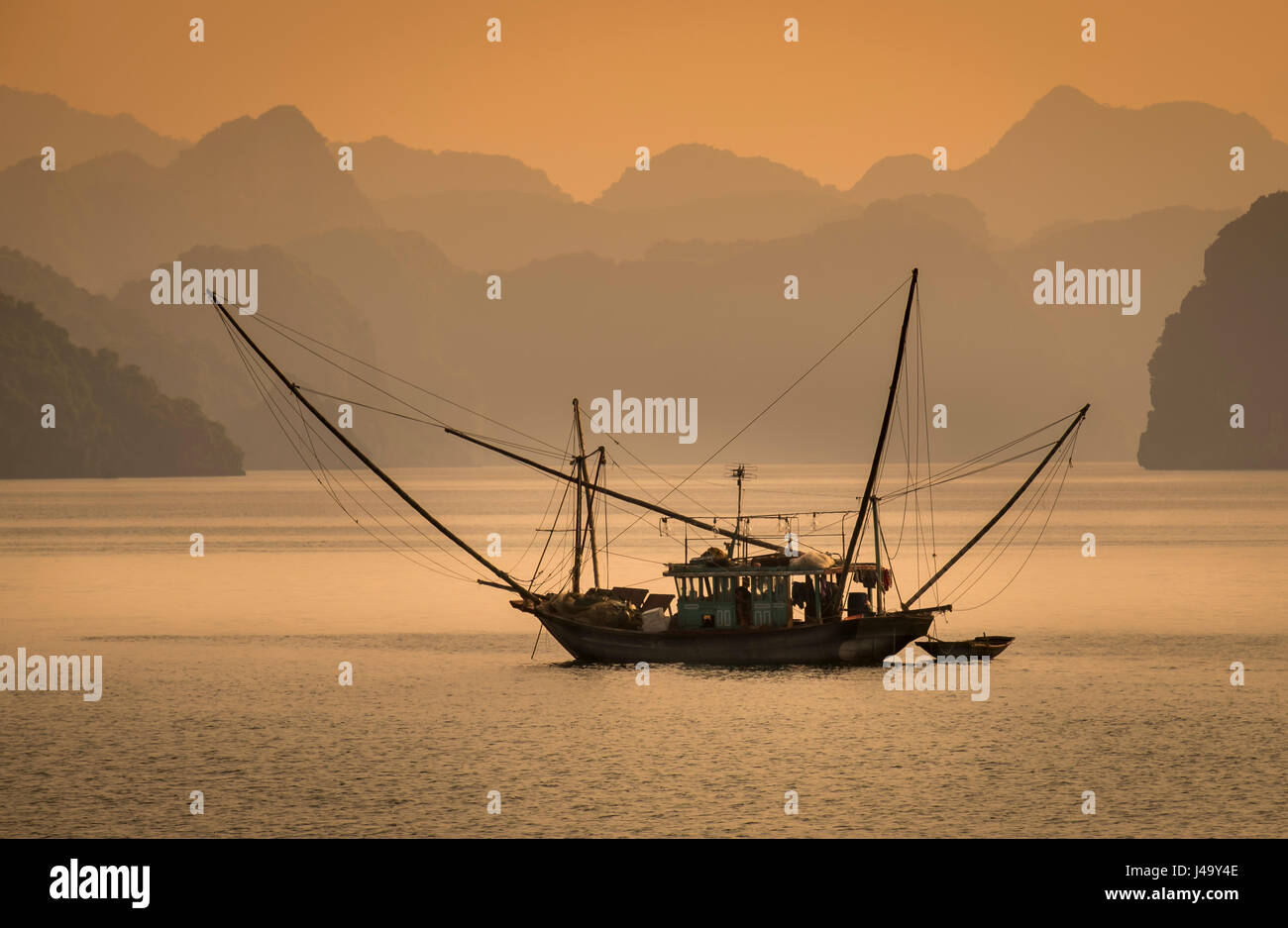 HA LONG BAY, VIETNAM - CIRCA SEPTEMBER 2014:  Fishing boat in Halong Bay, Vietnam at sunset. Stock Photo