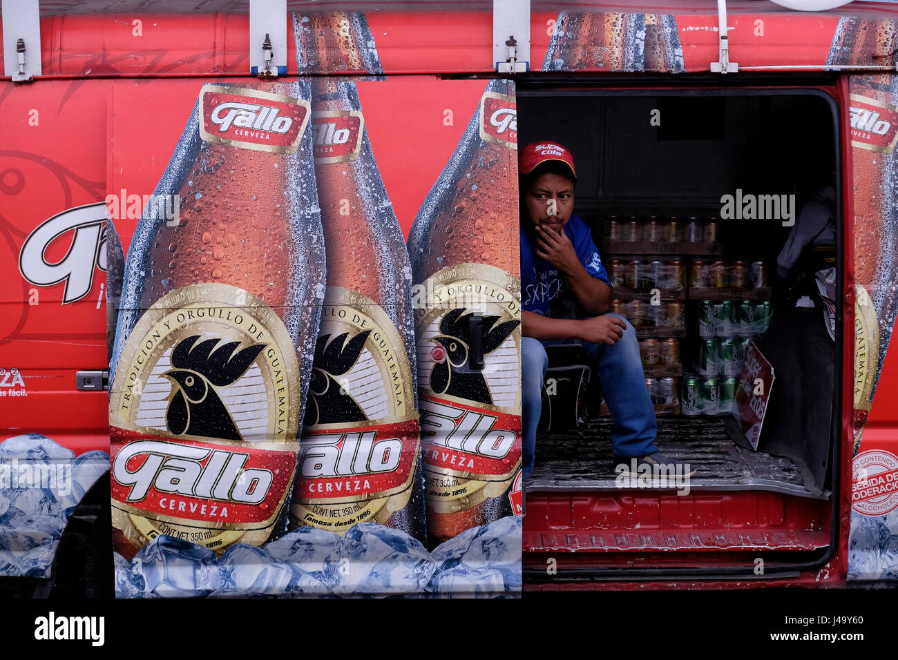 Man sitting in a transporter of Gallo Lager style beer brewed by Cerveceia Centro Americana in Guatemala city Stock Photo
