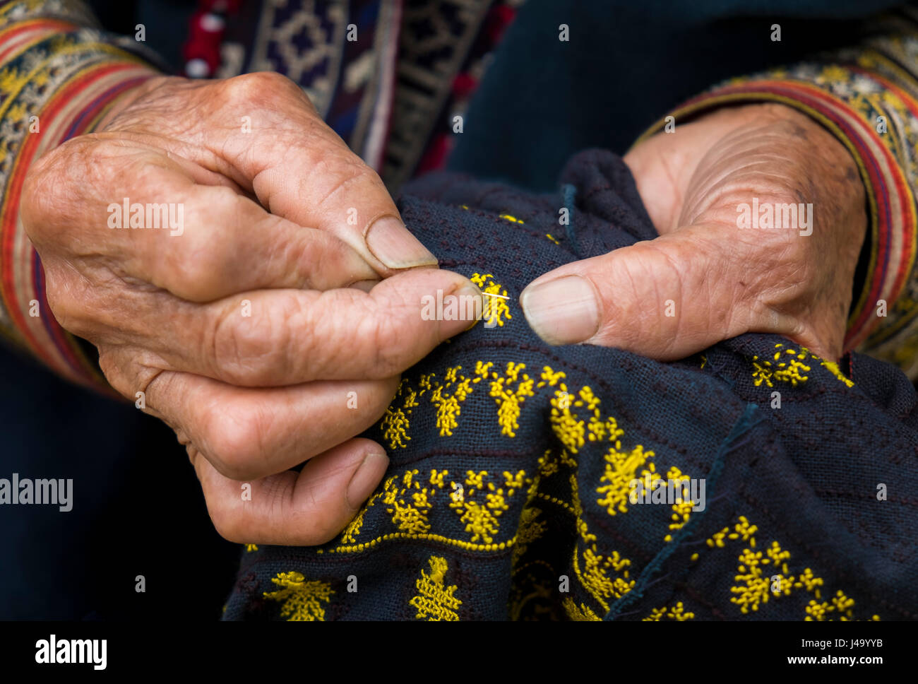 SAPA, VIETNAM - CIRCA SEPTEMBER 2014:  Detail of hands of old Red Dao woman knitting in Ta Phin Village near Sapa, North Vietnam. Stock Photo