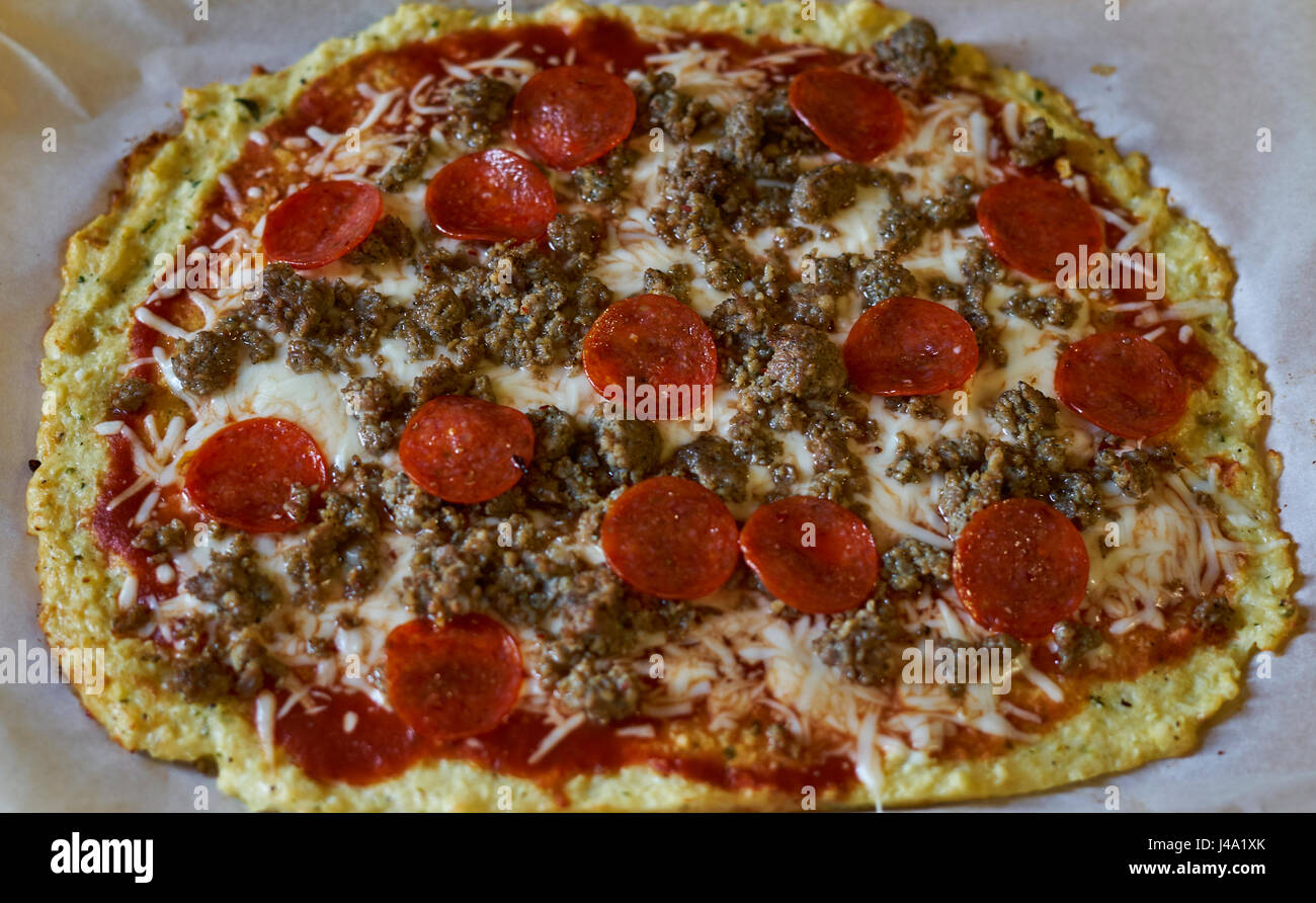 Cauliflower crust pizza with pepperoni and sausage. Stock Photo