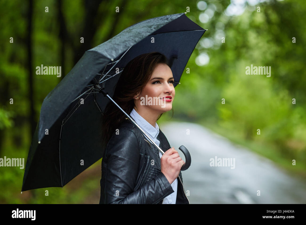 Young woman with umbrella outdoor in the park on a rainy day Stock ...