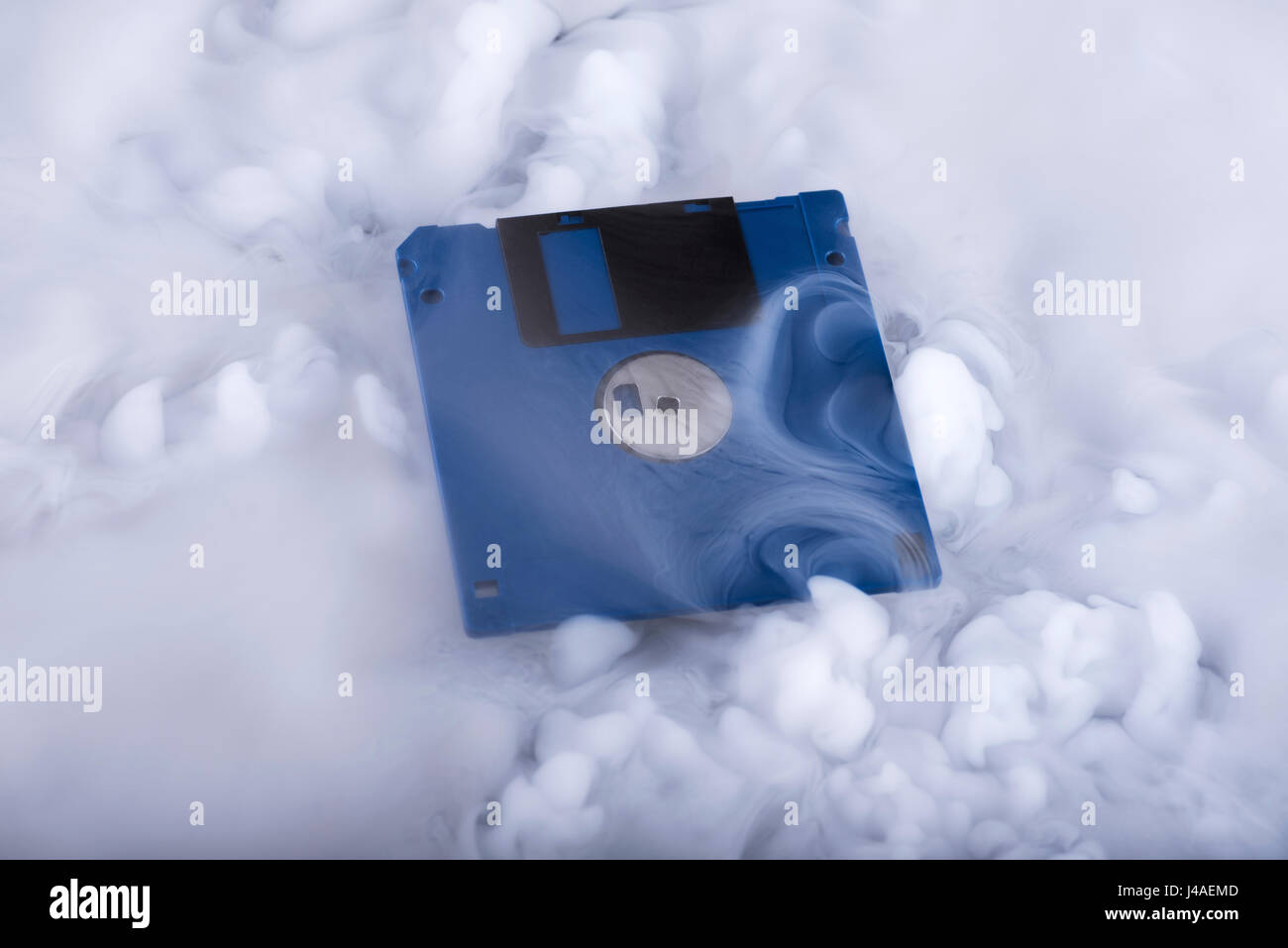 Blue retro floppy disk in clouds. Information cloud. Conceptual Stock Photo