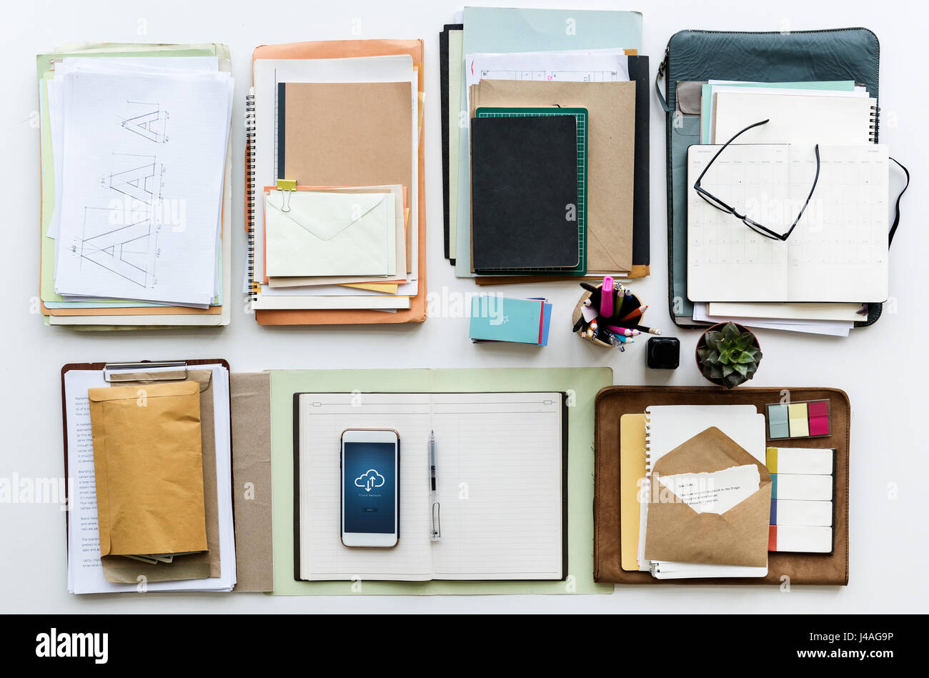 Office Desk with Notebooks and Stationery on White Table Stock Photo