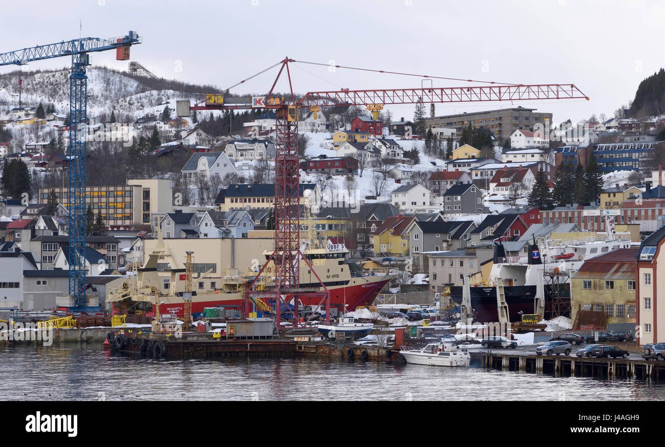 Cranes and ships on the waterfront of  Harstad harbour in winter. Harstad, Troms, Norway. Stock Photo