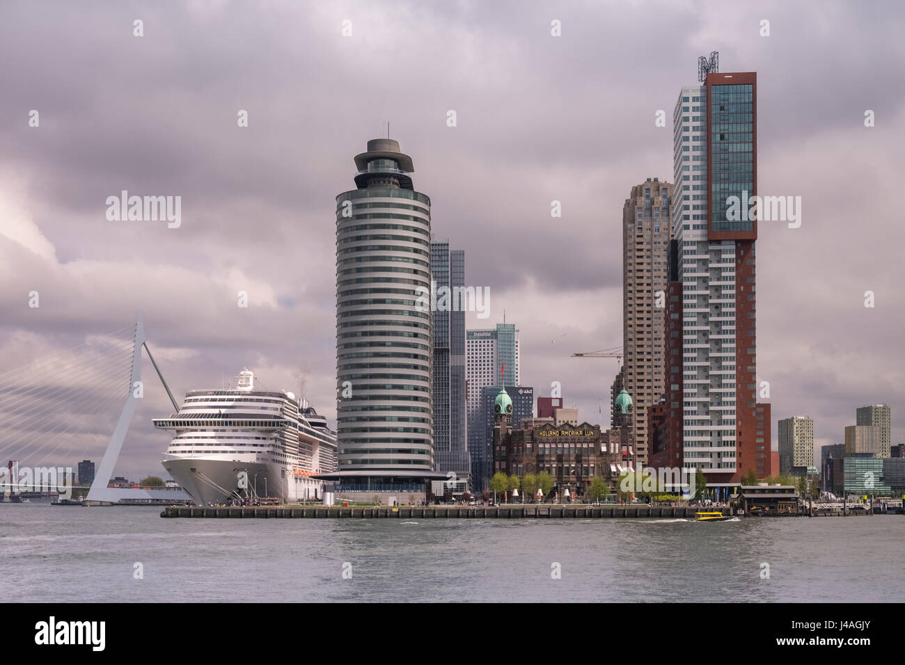 Modern large cruise ship at Wilhelmina Pier, with Erasmusbrug (Erasmus Bridge) in the background, Katendrecht, Rotterdam, The Netherlands. Stock Photo