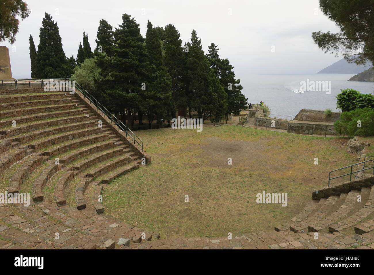 Remains of the theater on a hill in capital of Lipari island in Italy. It dates to Greek period, located on a hill at seaside of a town. Stock Photo