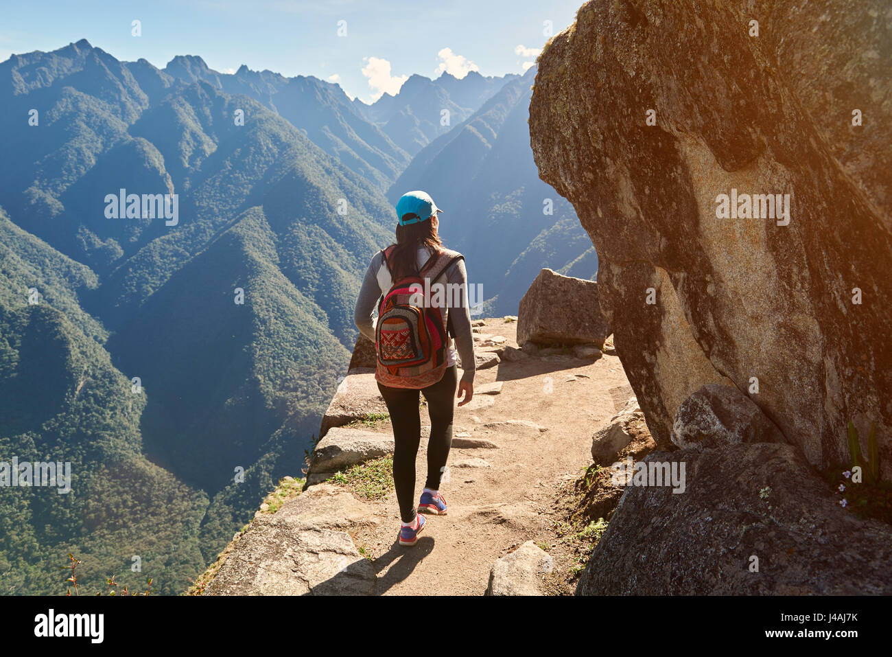Woman walk on narrow mountain path. Girl looking for freedom Stock Photo