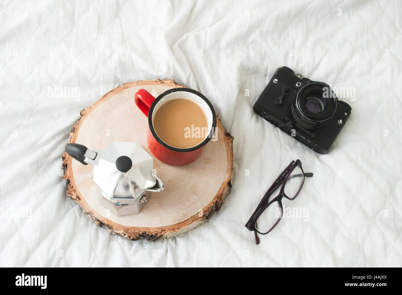 Blogger workspace with retro camera, glasses, and coffee cup and kettle on wooden table Stock Photo