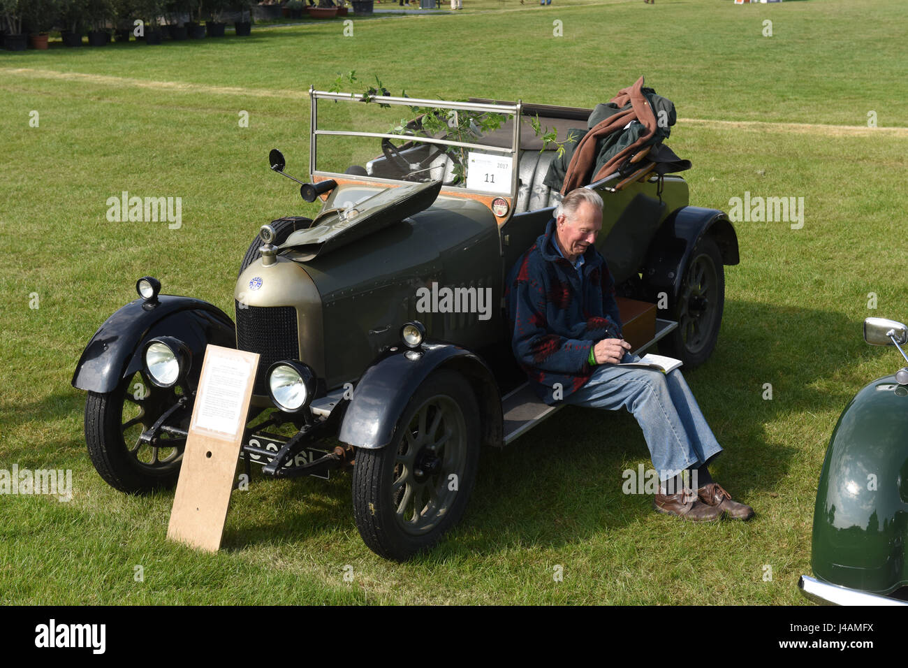 Classic car owner relaxing next to his 1925 Bullnose Morris vintage motor cars at Malvern Show Uk 2017 Stock Photo