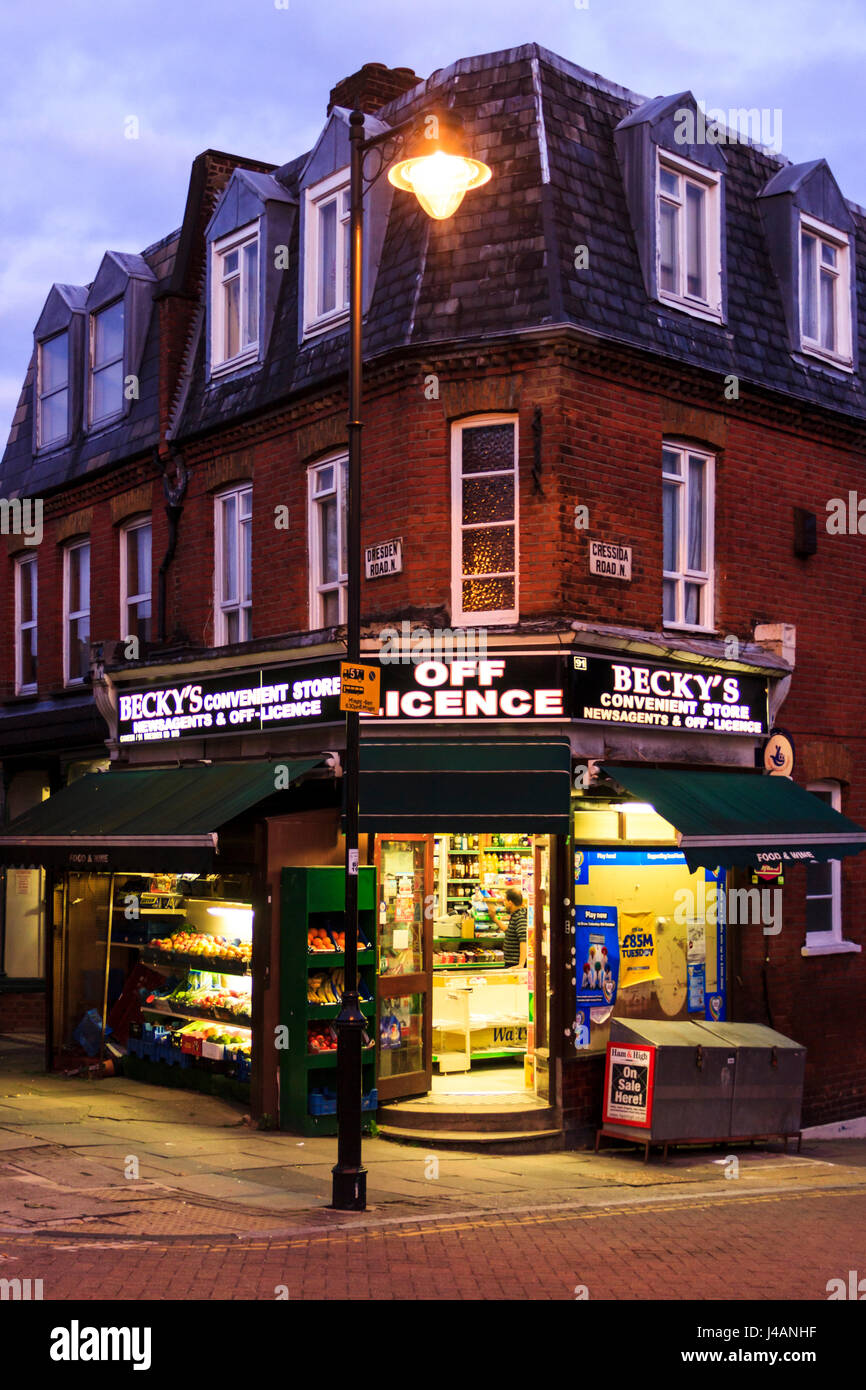 'Becky's' Off Licence, newsagent and convenience store, a traditional corner shop in Islington, North London, UK, at night Stock Photo