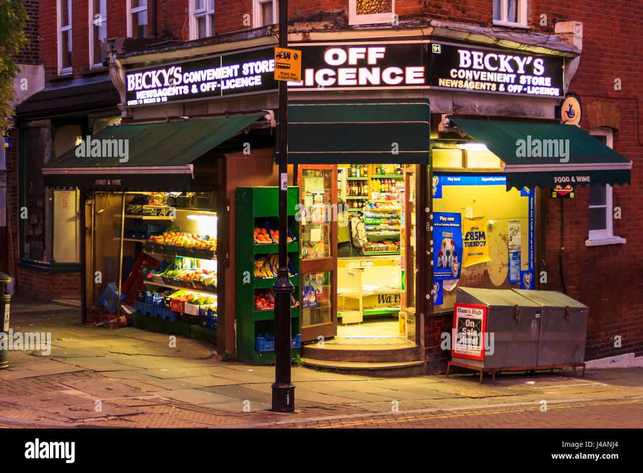 'Becky's' Off Licence, newsagent and convenience store, a traditional corner shop in Islington, North London, UK, at night Stock Photo