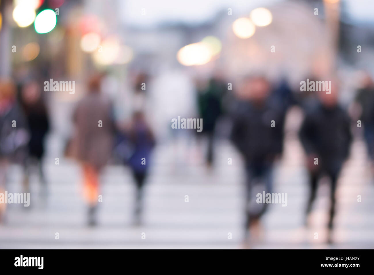 picture with motion blur of a crowd of people crossing a city street at ...