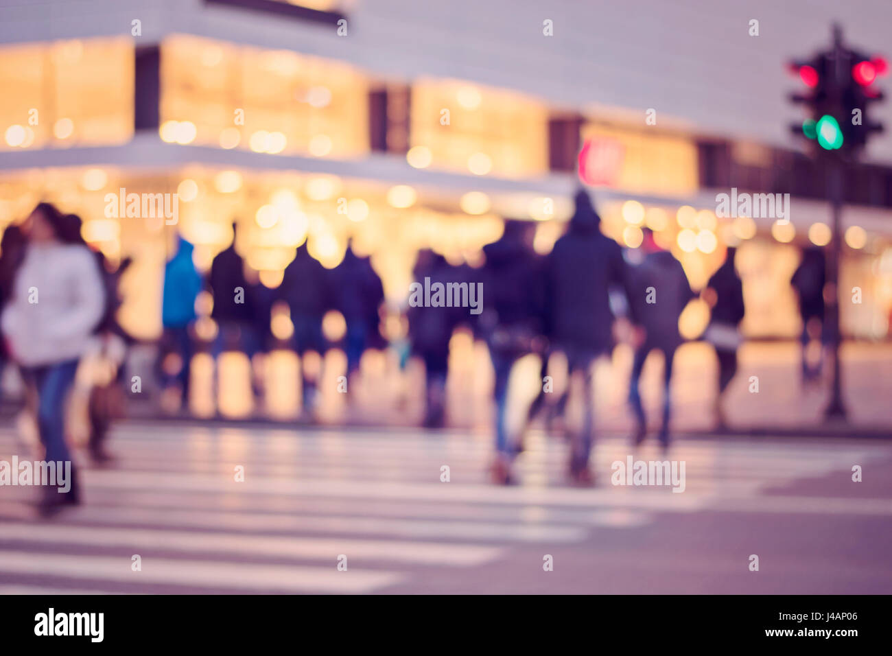 picture with motion blur of a crowd of people crossing a city street at ...
