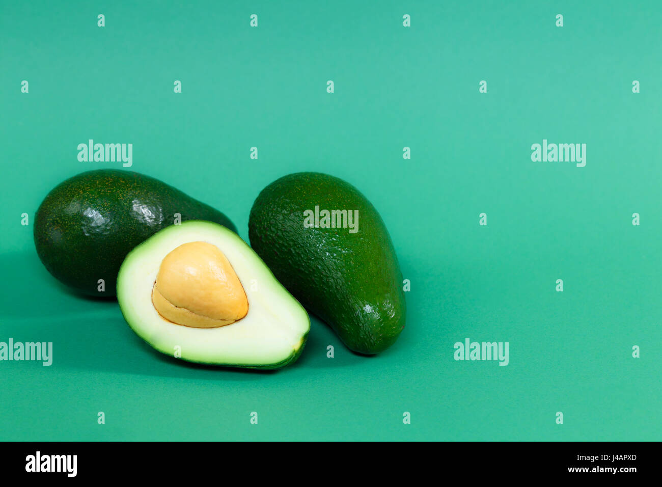 Avocado Ripened Color Fully ripened avocado on a green background Stock Photo - Alamy
