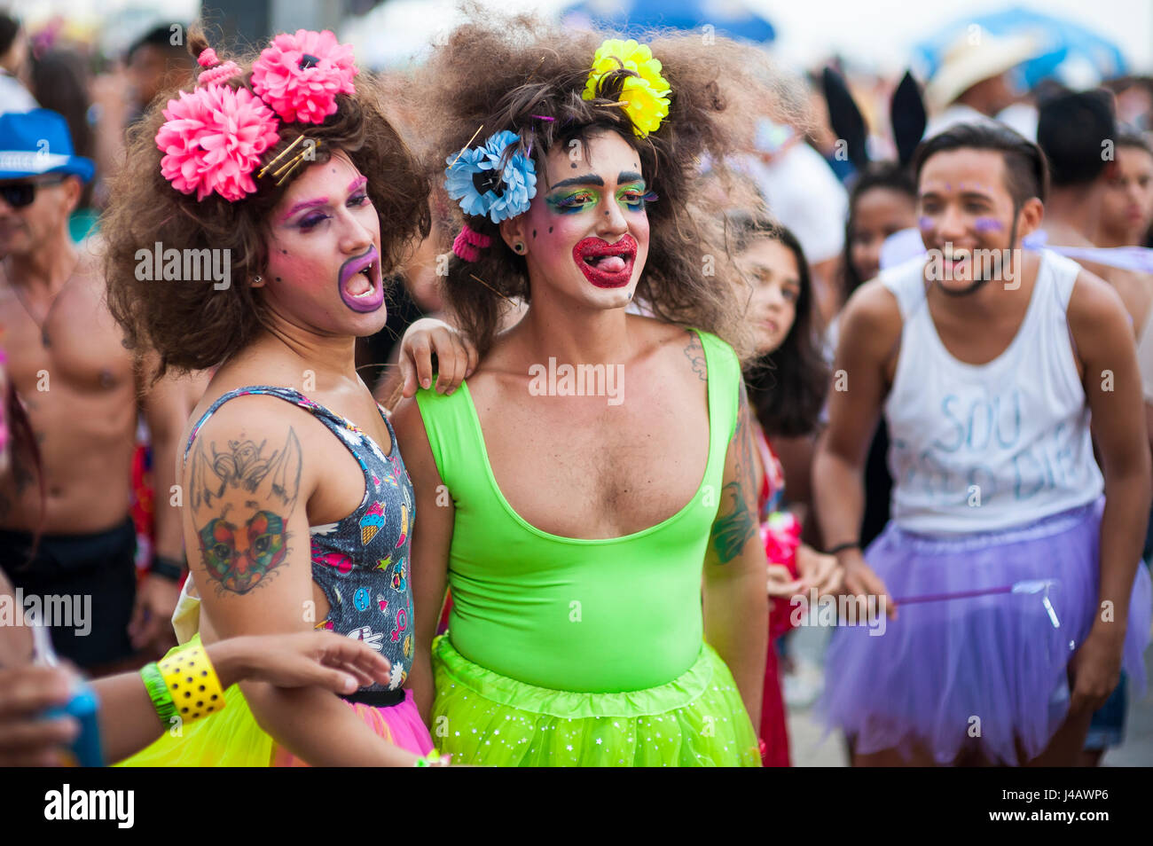 RIO DE JANEIRO - FEBRUARY 11, 2017: Brazilian men celebrate carnival with brightly colored makeup, dresses, and wigs at a street party in Ipanema. Stock Photo