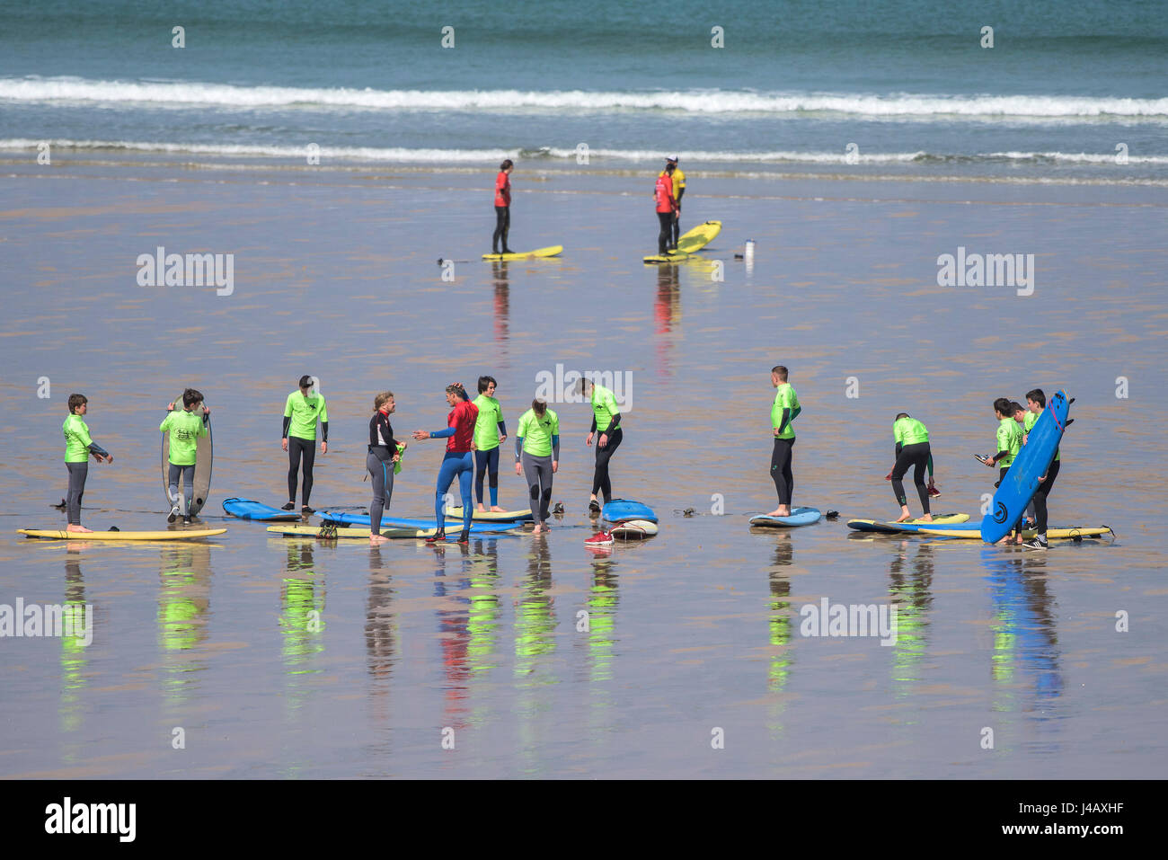 A surf school instructor teaching novices Newquay Cornwall Surfing Surfer Learners Learning