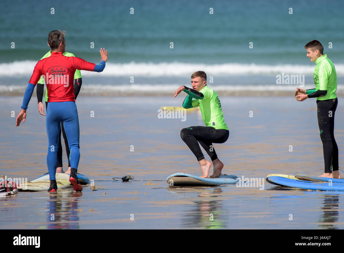 A surf school instructor teaching novices Newquay Cornwall Surfing Surfer Learners Learning Coaching Teaching Instructing Stock Photo