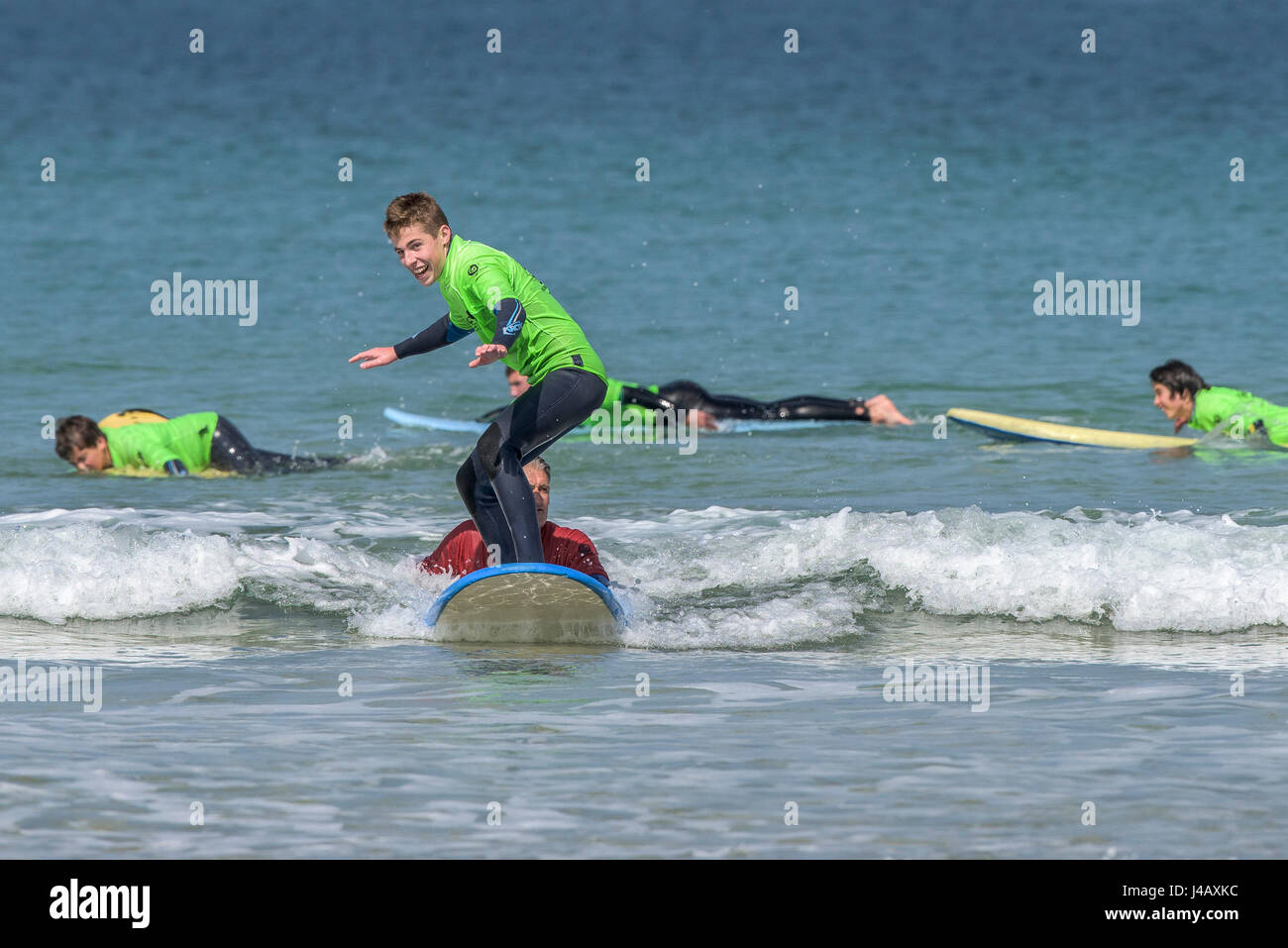 A surf school novice surfs for the first time Fistral Beach Newquay Cornwall Surfing Surfer Learner Learning Seaside Sea Tourism Stock Photo