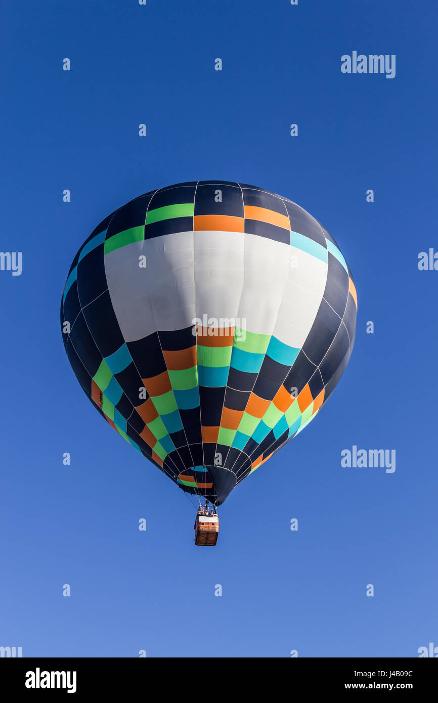 Colored hot air balloon flying in a blue sky Stock Photo - Alamy