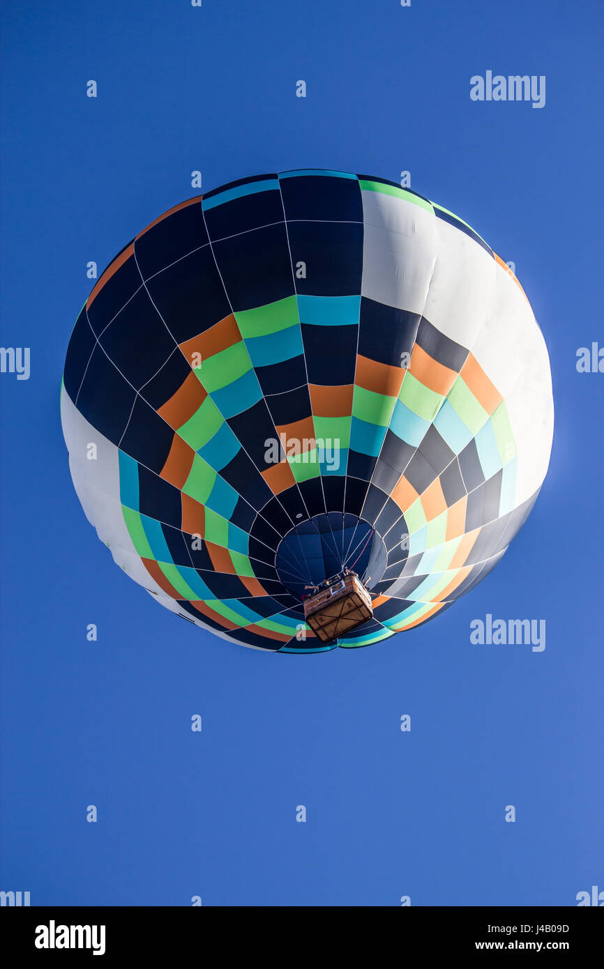 Colored hot air balloon flying in a blue sky Stock Photo - Alamy